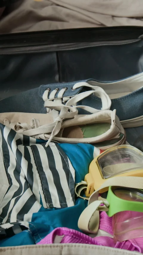 Vertical Hands of Black Man Putting Two Dive Masks in Suitcase for Vacation Stock Footage 333294088