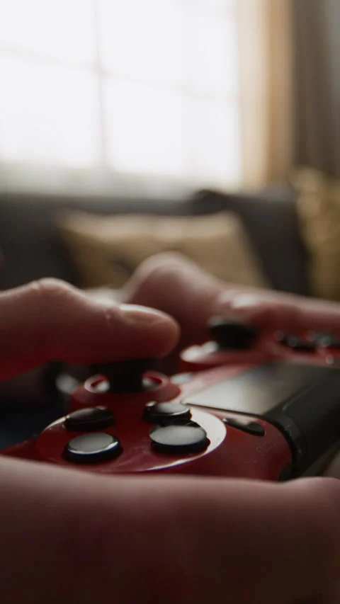Vertical of Hands of Gamer Playing with Red Wireless Controller Stock Footage 340776276