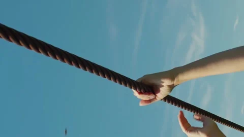 Vertical hands holding on to a steel cable Stock Footage 246958769