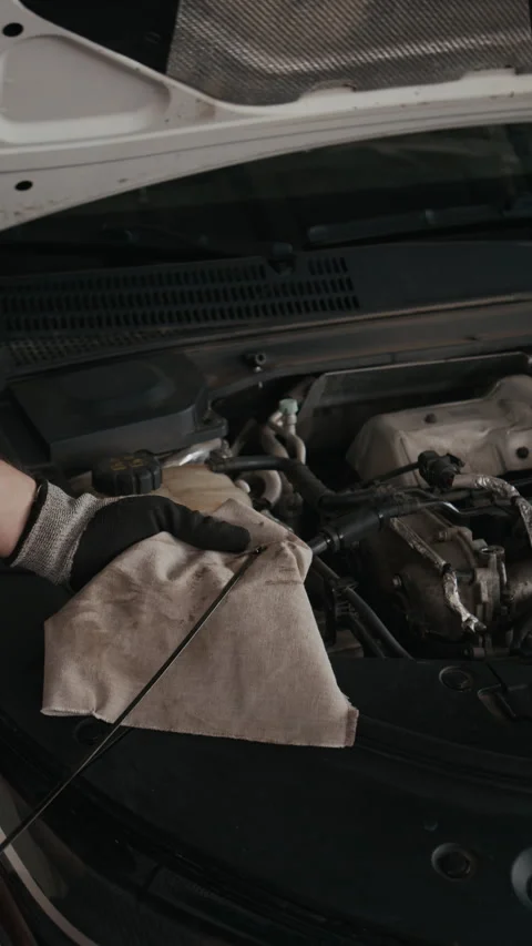 Vertical Hands of Mechanic Testing Engine Oil Level with Dipstick in Workshop Stock Footage 329479065