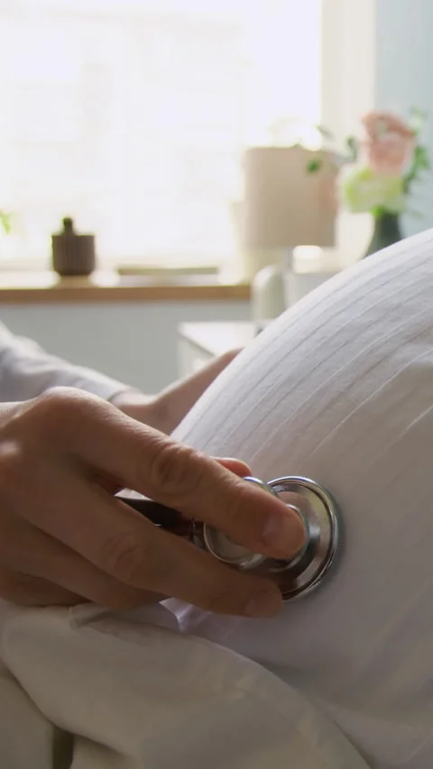 Vertical of Hands of Midwife with Stethoscope Checking Fetus Heartbeat Stock Footage 313957973