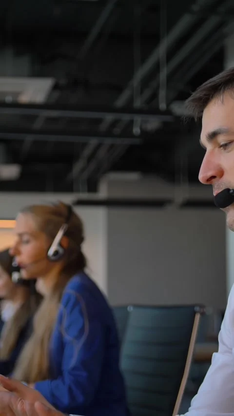 Vertical of Handsome worker in office call-center talking with client and then Stock Footage 277283400
