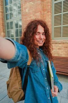 Vertical. Happy non-binary student taking a selfie outdoors, smiling confid.. Stock Photos