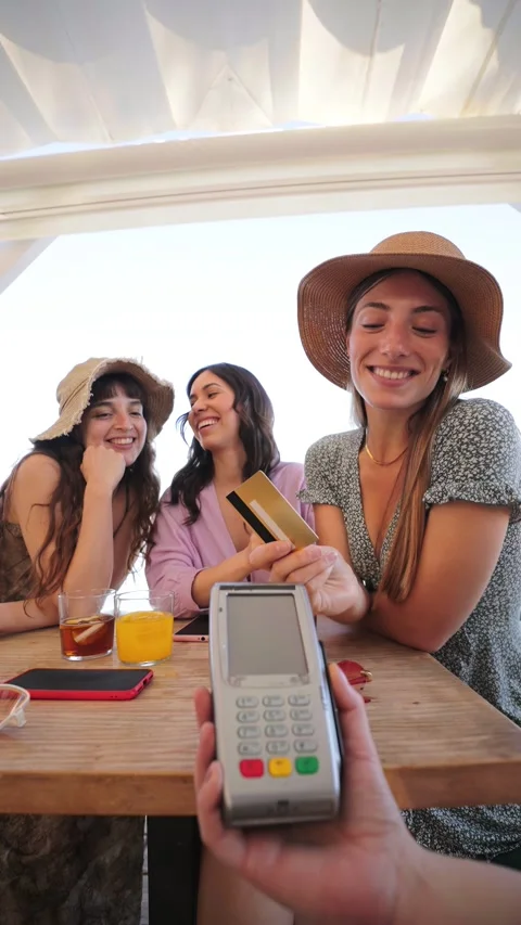 Vertical. Happy young group of only women paying the bill with a contactless Stock Footage 277397933