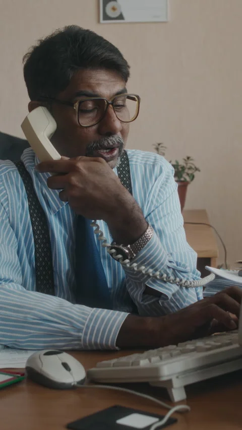 Vertical of Hardworking Man Working on Computer and Answering Call in 80s Stock Footage 280665215