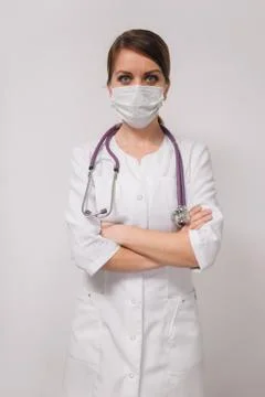 Vertical head shot concept. Young beautiful woman doctor in medical mask in a Stock Photos