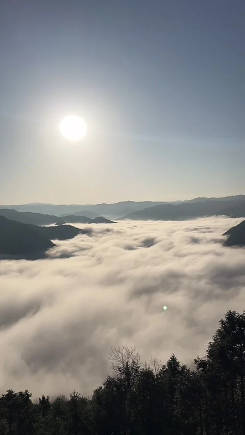 Vertical High Altitude Mountain View of White Cloud Ocean and Sun Stock Footage 332525057