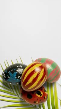 A vertical high-angle shot of four uniquely hand-painted Easter eggs restin.. Stock Photos