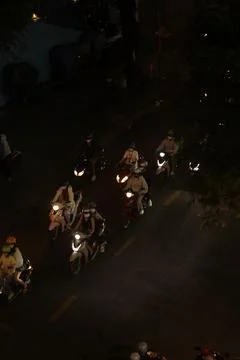 Vertical high angle shot of motorbikes riding on a dark city road at night Stock Photos