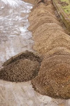 Vertical high angle shot of piles of sand in an area of construction Stock Photos