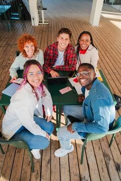 Vertical high angle view of diverse group of smiling students looking at ca.. Stock Photos