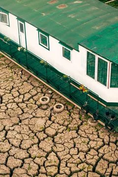 Vertical high angle view of a white and green houseboat grounded on deeply .. Stock Photos