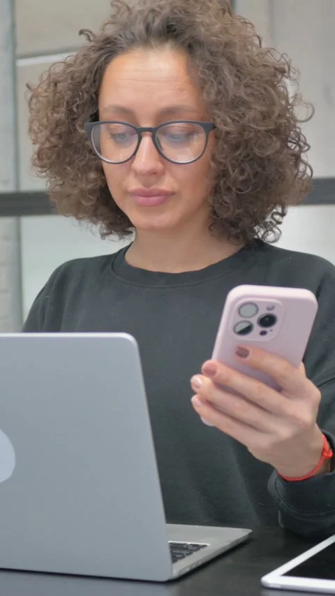 Vertical, Hispanic Woman Working on Multiple Digital Devices at Work Stock Footage 325561171