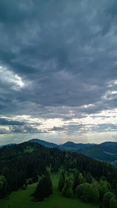 Vertical Hyperlapse of Lush Green Hills with Sun Rays and Moving Clouds in Stock-Footage 317643125