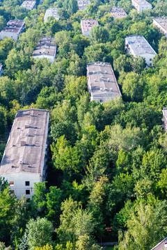 Vertical image with above view of the city houses roofs in the woodland Stock Photos