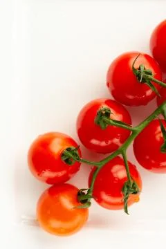 Vertical image with cherry tomatoes on white surface Stock Photos