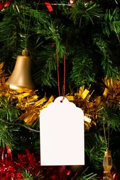 Vertical image of close up of christmas tree with baubles, decorations and tag Stockfoto's