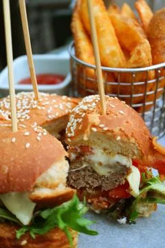 Vertical Image of Cut Thick and Cheesy Burger with French Fries Photos