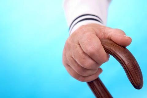 Vertical image of elderly human hand leaning on cane handle Photos