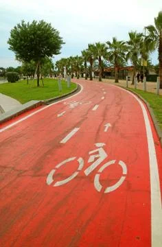 Vertical Image of an Empty Vibrant Red Bicycle Lane in the Park Photos