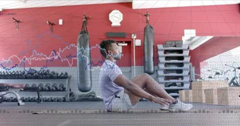 Vertical image: Man tensing core and doing sit-ups on gym mat, waveform tracking Foto stock