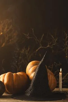 Vertical image of pumpkins and witch hat and burning candle with copy space on 写真素材