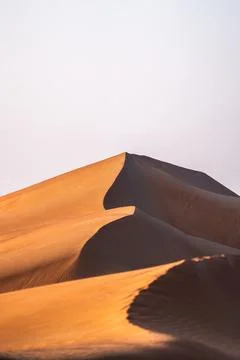 Vertical image of sand dunes creating abstract patterns in desert landscape Stock Photos