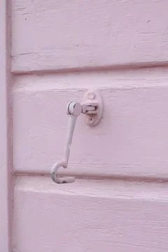 Vertical image of soft pink painted panelled wood and retaining hook Stock Photos