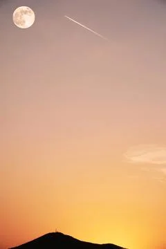Vertical image with a space shuttle flying to the moon in sunset lights Foto stock