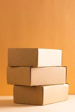 Vertical image of stack of cardboard gift boxes with copy space over yellow Stock Photos