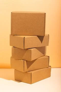 Vertical image of stack of cardboard gift boxes with copy space over yellow Foto stock