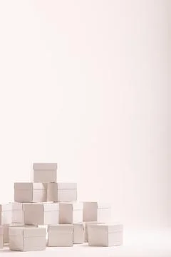 Vertical image of stack of white gift boxes and copy space over white background 스톡 사진