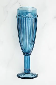 Vertical image of a thick blue glass champagne flute with faceted sides Stock Photos