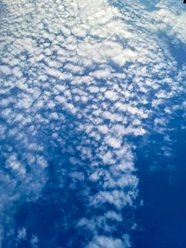 Vertical image of wisps of clouds in a clear blue sky Stock Photos
