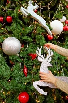 Vertical Image of Woman's Hands Decorating Glitter Reindeer Shaped Ornament Photos
