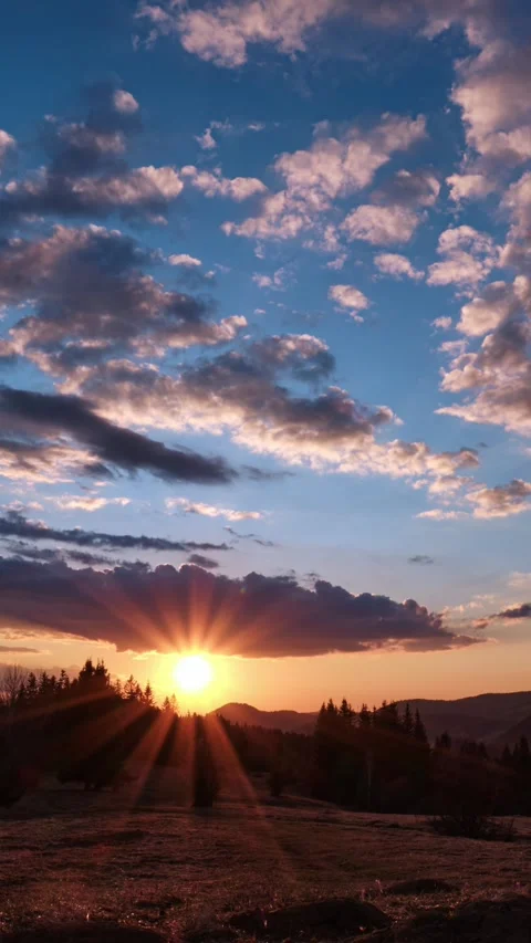 Vertical imelapse of sunset and twilight with colorful clouds, sun rays, and Stock-Footage 305995051