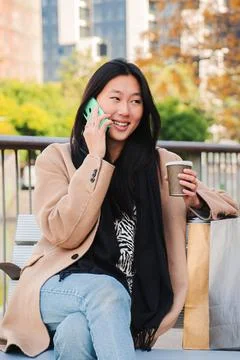 Vertical individual portrait of a happy asian young woman calling using a cell Stock Photos
