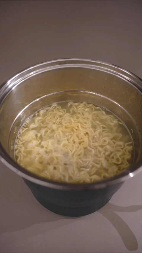 Vertical Instant Noodles Boiling in Electric Cooking Pot Stock Footage 345517516