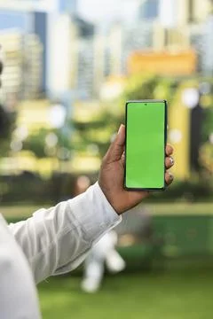Vertical isolated green screen on mobile phone held by businessman Stock Photos