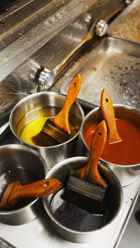 Vertical kitchen close up of brushes and sauces for Asian barbecue 스톡 동영상 333877647