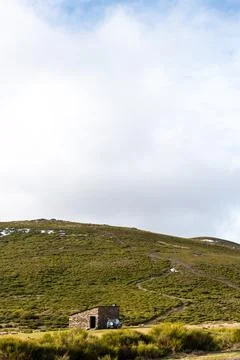 Vertical landscape view of a mountain side with a shelter and an off-road car Stock Photos
