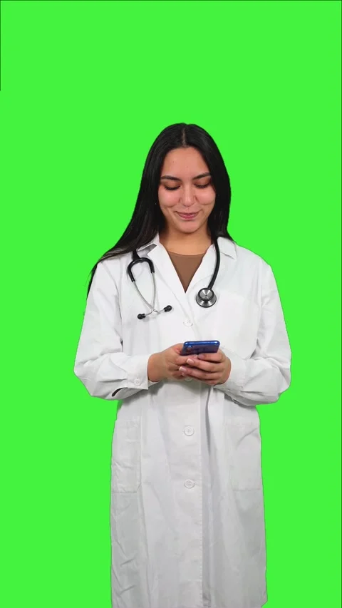 Vertical Latin Female Doctor Using Smartphone on Green Screen Stock Footage 308743224