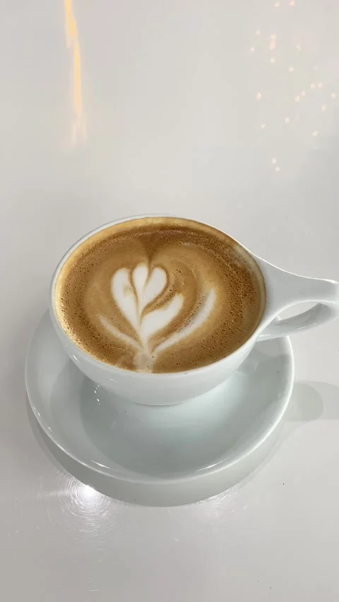 Vertical Latte Art Coffee Cup on White Table in Modern Cafe, 4K Stock Footage 323570913