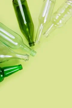 Vertical layout of empty bottles on green background Stock Photos