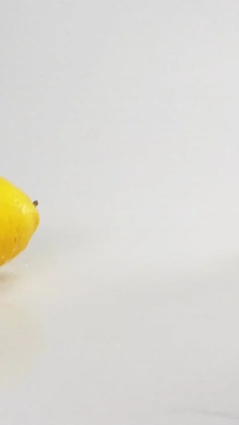 Vertical of lemons fall down at white wet surface Stock Footage 305513822