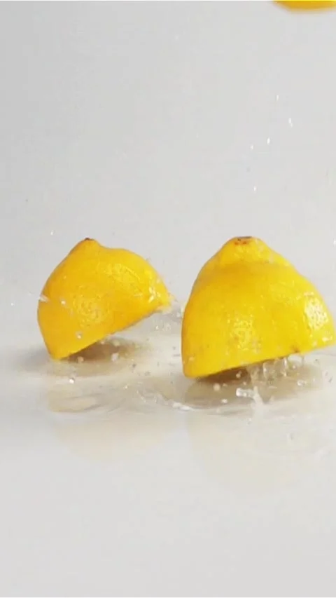 Vertical of lemons fall down at white wet surface Stock Footage 305516892