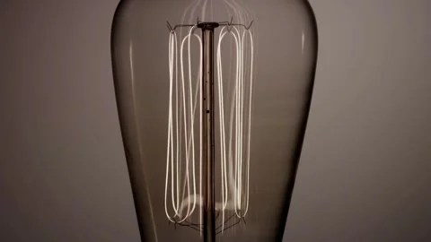 Vertical light bulb filaments glow with a warm light Stock Footage 329656872