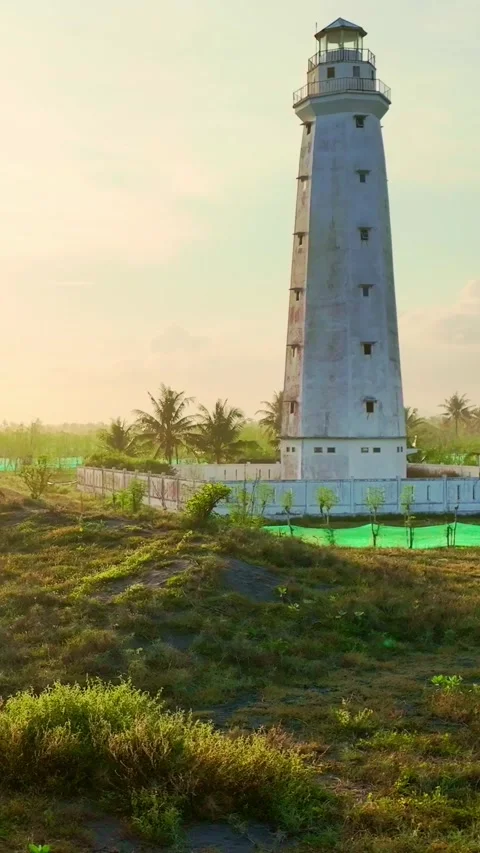 Vertical lighthouse view over tropical coastal farmland Stock Footage 335432328