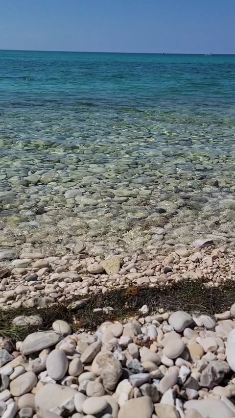 Vertical limestone beach with crystal clear water and radiant sun Vidéo 329072529