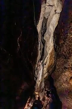 Vertical limestone column nestled inside a narrow rock fissure in a cave, P.. Stock Photos